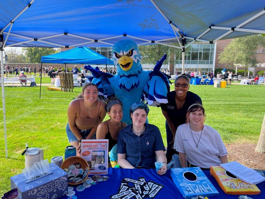 students smiling with Swoop the Hawk